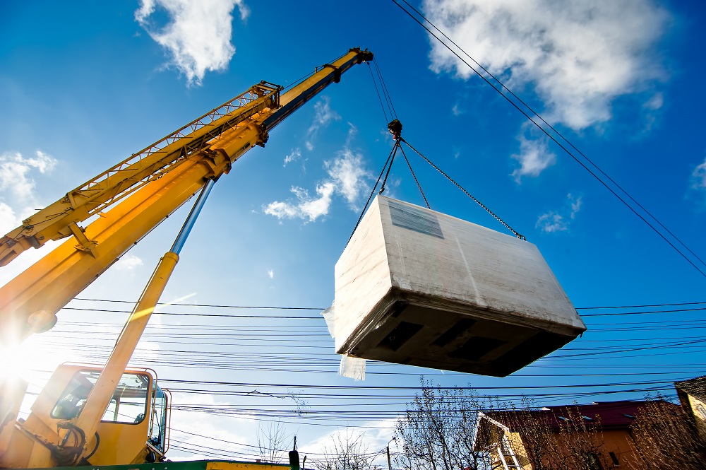 Industrial,Crane,Operating,And,Lifting,An,Electric,Generator,Against,Sunlight